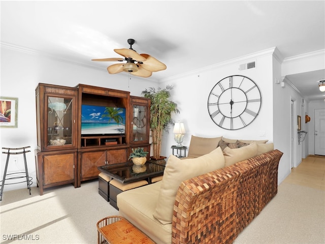 living room featuring ceiling fan, ornamental molding, and light carpet