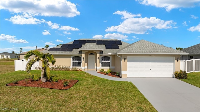 view of front of property with a garage, a front yard, and solar panels