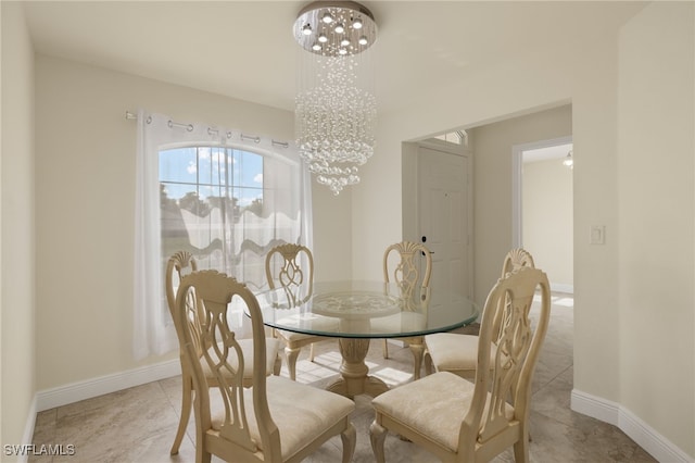 dining area with light tile patterned flooring and a chandelier