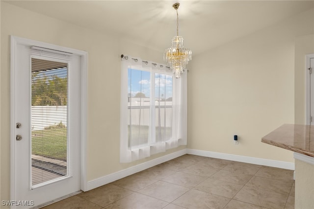 unfurnished dining area featuring a healthy amount of sunlight, light tile patterned floors, and a notable chandelier