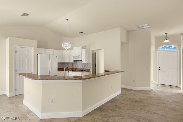 kitchen featuring white cabinetry, vaulted ceiling, hanging light fixtures, white appliances, and a kitchen island with sink