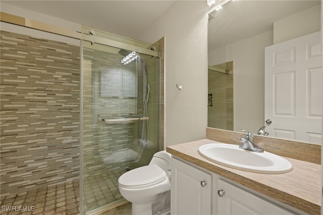 bathroom featuring vanity, an enclosed shower, and toilet