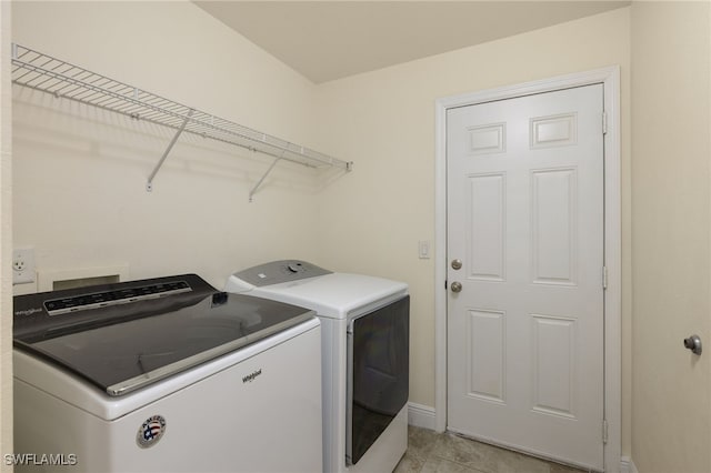 clothes washing area featuring separate washer and dryer and light tile patterned flooring