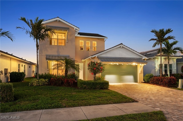 view of front of home featuring a garage and a lawn