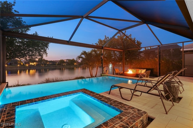 pool at dusk featuring a water view, an outdoor fire pit, a lanai, and a patio