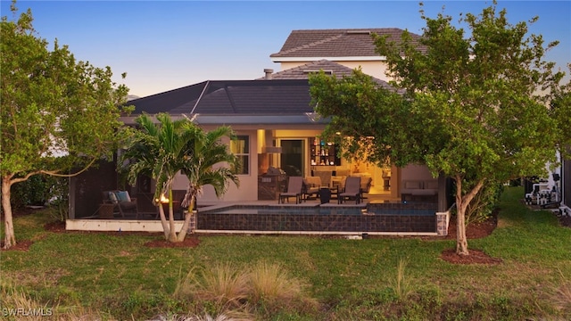 8949 Mustique Ln, Naples, FL 34114 - back of property featuring a patio, a lawn, stucco siding, and a tile roof