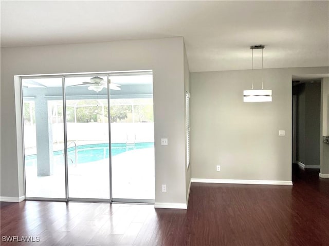 empty room with dark hardwood / wood-style flooring and ceiling fan