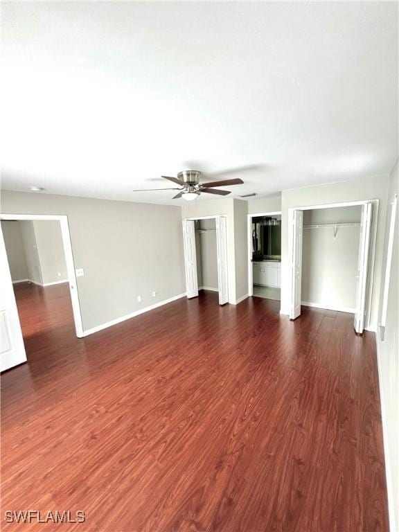 unfurnished living room featuring ceiling fan and dark hardwood / wood-style floors