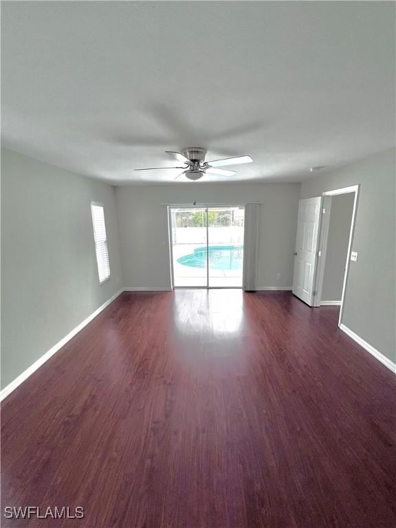 empty room with dark wood-type flooring and ceiling fan