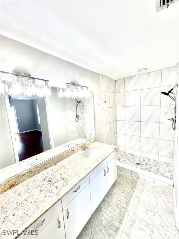 bathroom with vanity and a tile shower