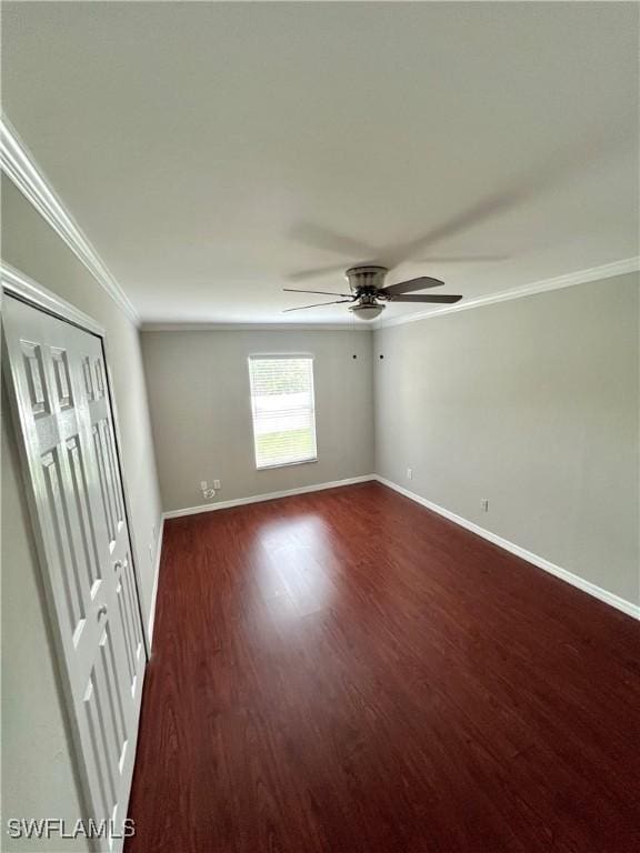 spare room featuring dark wood-type flooring, ceiling fan, and ornamental molding