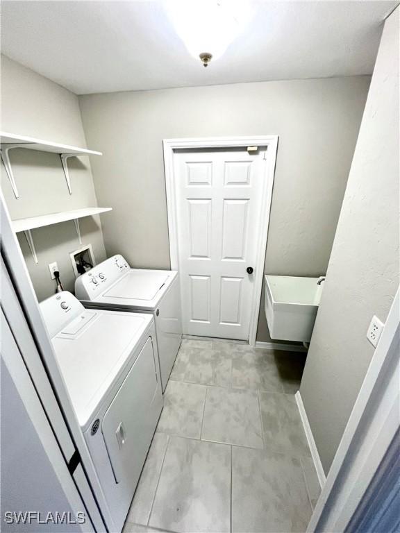 laundry area featuring light tile patterned flooring and washer and clothes dryer