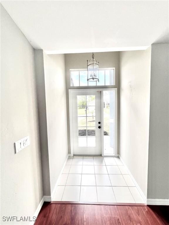 doorway to outside featuring a chandelier and light hardwood / wood-style flooring