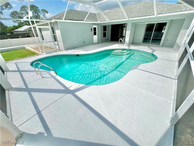 view of pool with a patio and glass enclosure