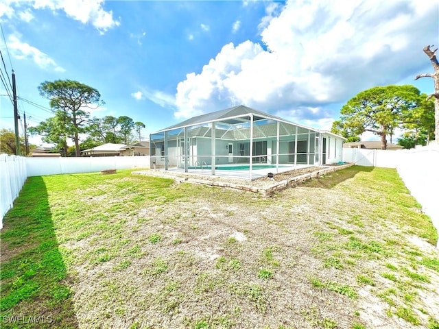 rear view of property featuring glass enclosure, a fenced in pool, and a lawn