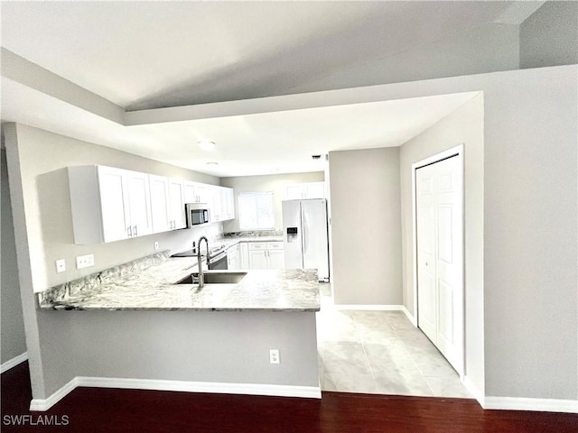 kitchen with sink, white cabinets, white refrigerator with ice dispenser, kitchen peninsula, and light wood-type flooring