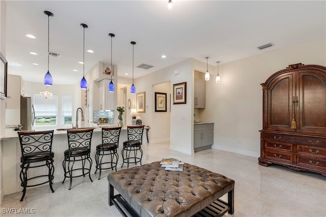 kitchen with stainless steel refrigerator, a breakfast bar area, and hanging light fixtures