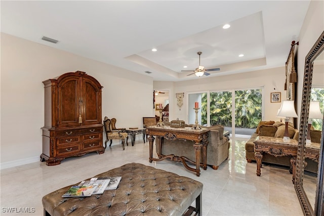 living room featuring recessed lighting, a raised ceiling, a ceiling fan, and light tile patterned floors