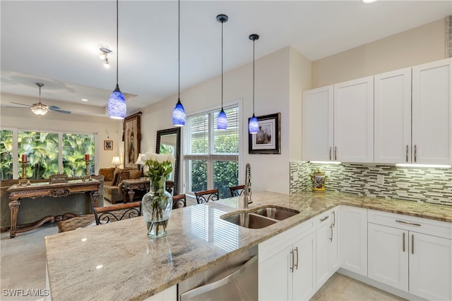 kitchen with sink, dishwasher, white cabinets, and decorative backsplash