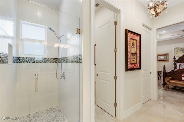 ensuite bathroom with a notable chandelier, a wealth of natural light, a shower stall, and connected bathroom