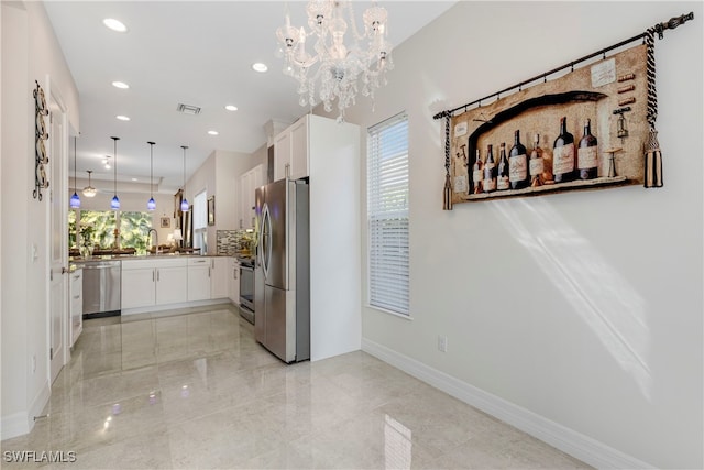 kitchen with white cabinetry, stainless steel appliances, a wealth of natural light, and pendant lighting