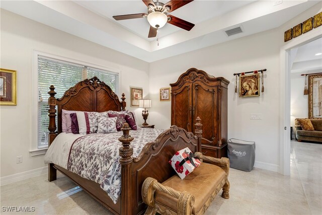 bedroom with baseboards, a ceiling fan, visible vents, and a tray ceiling