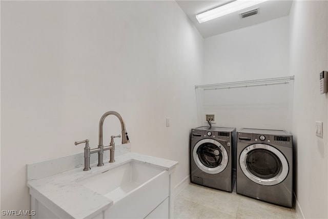 laundry room featuring washer and clothes dryer, laundry area, visible vents, a sink, and baseboards