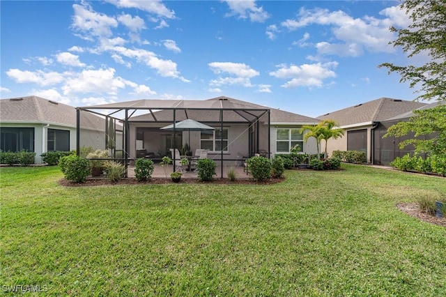 rear view of house featuring a patio, glass enclosure, and a lawn