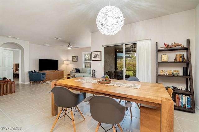 tiled dining area featuring ceiling fan with notable chandelier