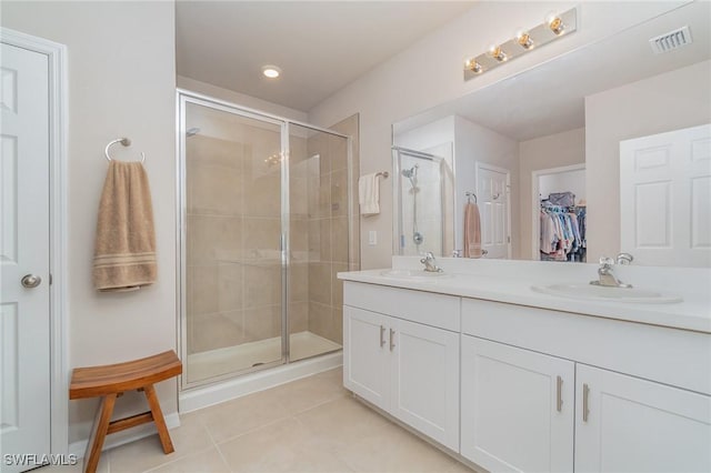 bathroom featuring tile patterned flooring, vanity, and a shower with shower door