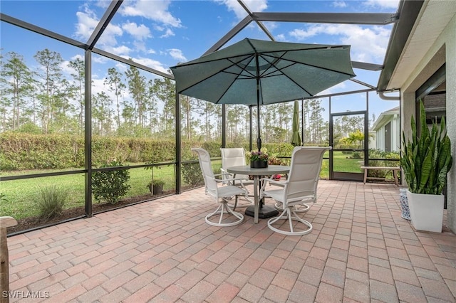 view of patio featuring glass enclosure