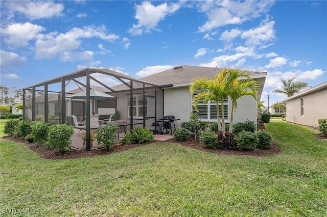 rear view of property with a patio area, glass enclosure, and a lawn