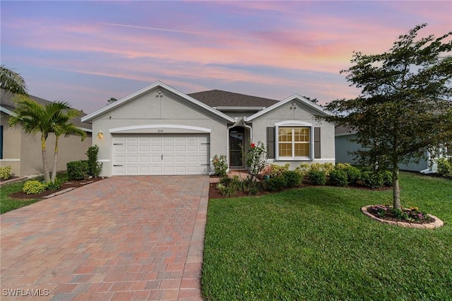 ranch-style home featuring a garage and a lawn