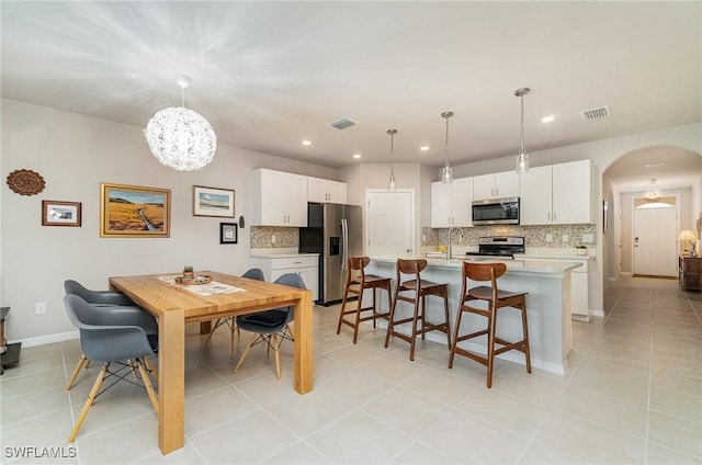 tiled dining space with sink and an inviting chandelier