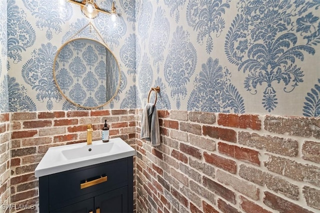 bathroom with brick wall and vanity