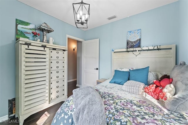 bedroom featuring wood-type flooring and a chandelier
