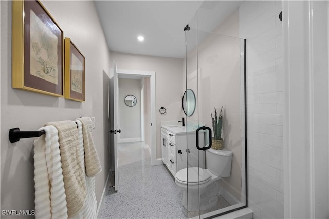 bathroom with a shower with door, vanity, and toilet