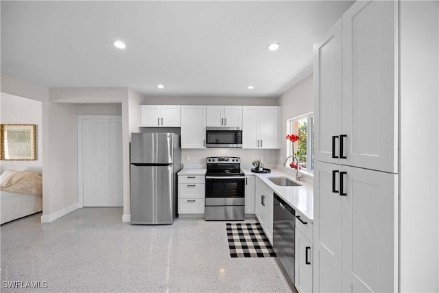 kitchen featuring stainless steel appliances, white cabinetry, and sink