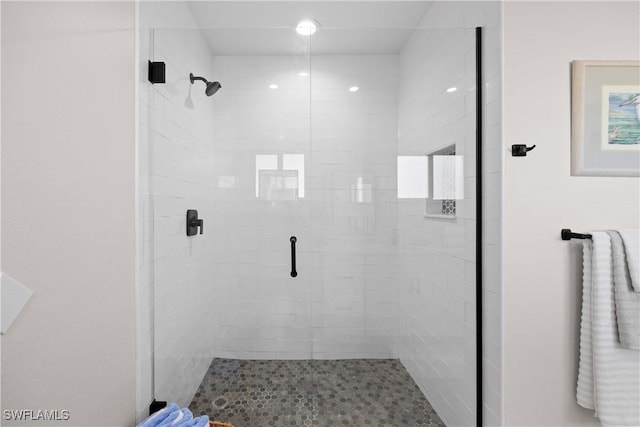 bathroom featuring a shower with door