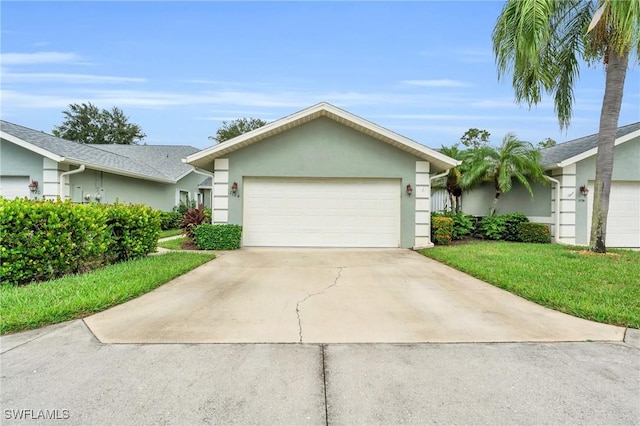 single story home featuring stucco siding, a front yard, a garage, and driveway