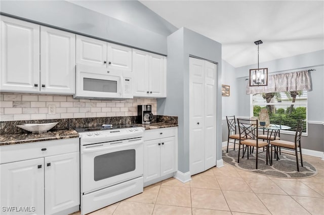 kitchen featuring lofted ceiling, light tile patterned flooring, white appliances, white cabinets, and decorative backsplash