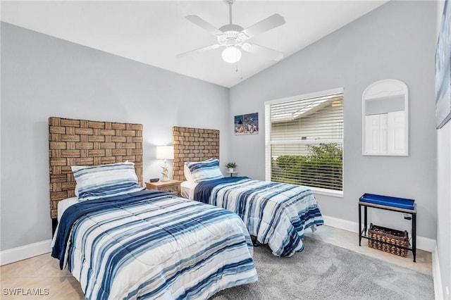 bedroom featuring a ceiling fan, vaulted ceiling, baseboards, and light tile patterned floors