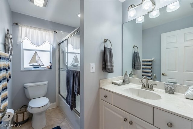 bathroom featuring toilet, shower / bath combination with glass door, tile patterned flooring, and vanity