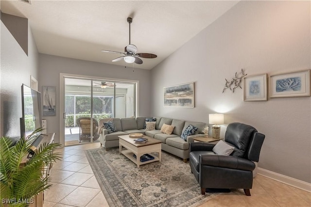 living room with a ceiling fan, lofted ceiling, baseboards, and light tile patterned floors