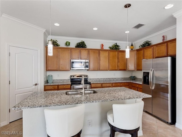 kitchen featuring stainless steel appliances, light stone countertops, a kitchen island with sink, and decorative light fixtures