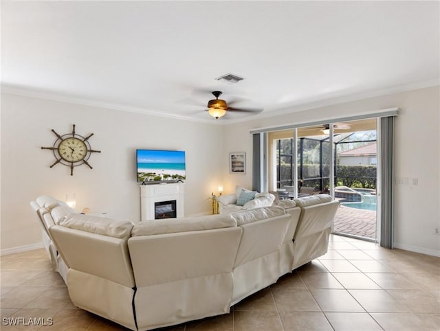 living room with ornamental molding, ceiling fan, and light tile patterned flooring