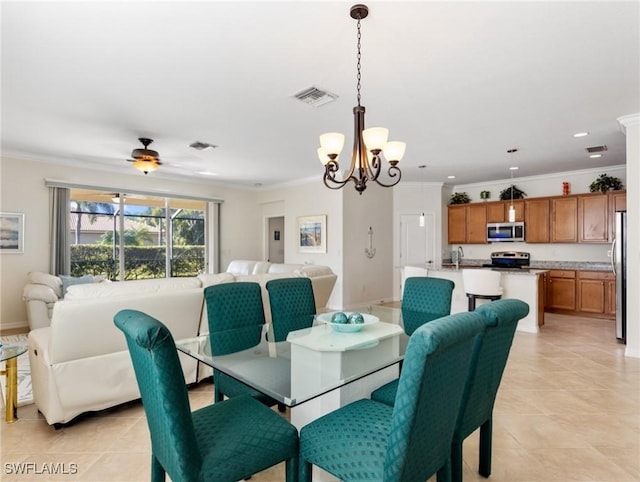 dining area featuring crown molding, ceiling fan with notable chandelier, sink, and light tile patterned floors