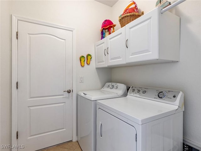 laundry area featuring cabinets, washer and dryer, and light tile patterned floors