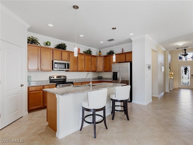 kitchen with sink, light stone counters, decorative light fixtures, a center island with sink, and stainless steel appliances