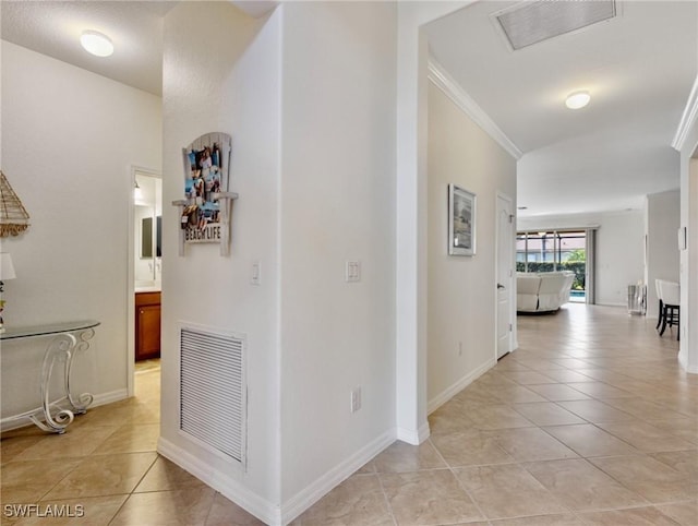 corridor featuring light tile patterned flooring and ornamental molding